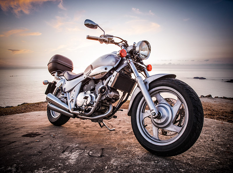 Motorcycle Insurance - A Shiny motorcycle on a point overlooking the sea.