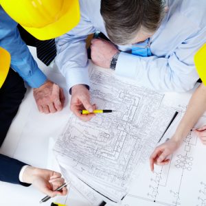 Contractors Insurance - A group of professionals confers over a set of blueprints.